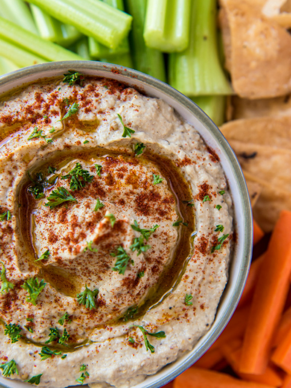 overhead shot of Baba Ghanoush in a bowl served with veggies and pita chips