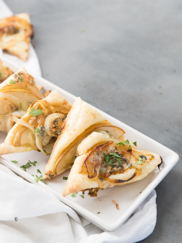 pear and blue cheese pastry triangles on a white platter