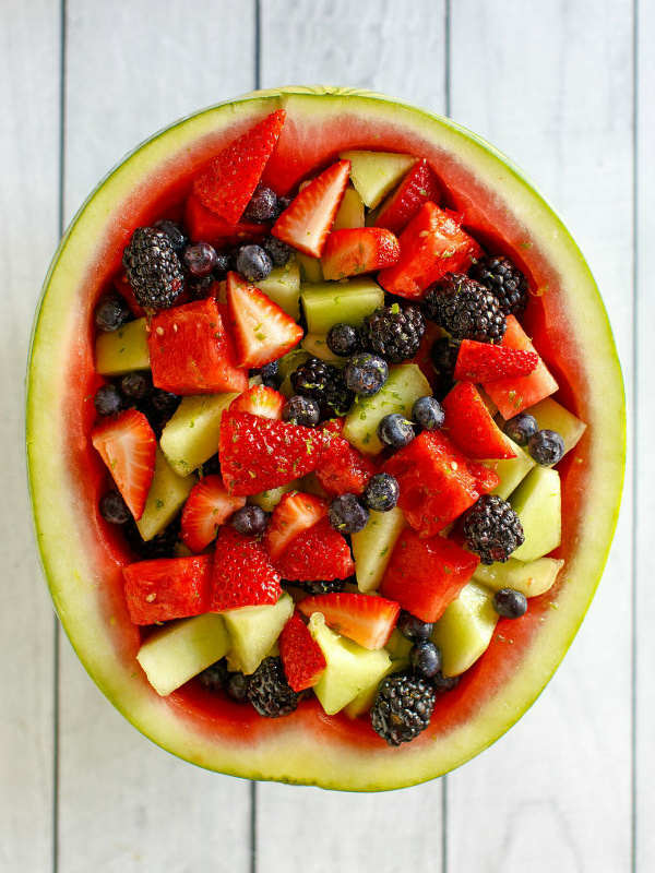 overhead shot of watermelon fruit bowl sitting on a white wood background surface