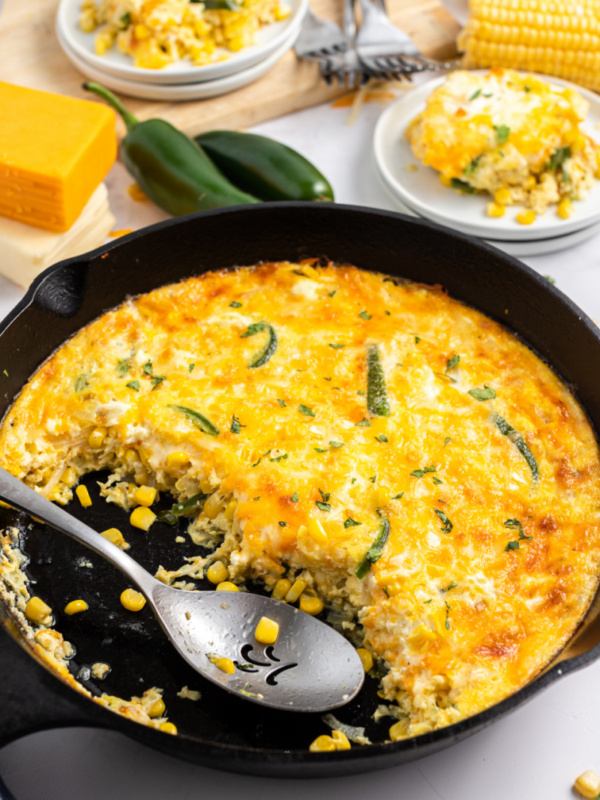 spooning cheese souffle out of cast iron skillet