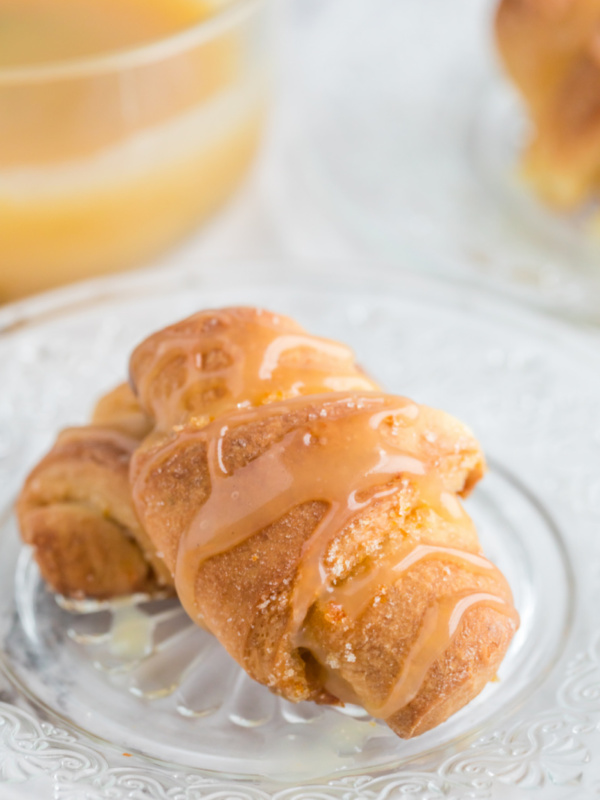 orange sticky buns on a plate with glaze