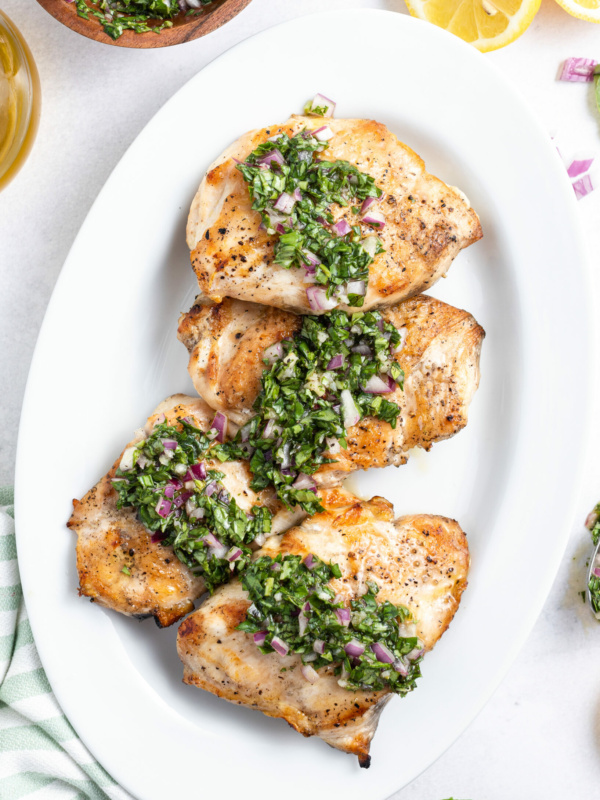 grilled chicken with basil chimichurri on a white platter