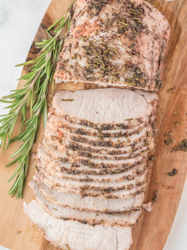 rosemary pork roast sliced on wood board