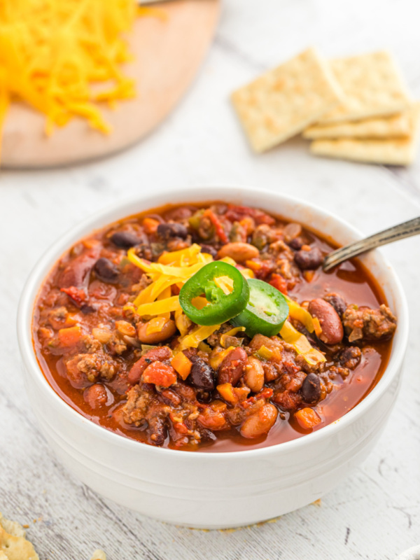 bowl of chili with cheese and jalapeno on top