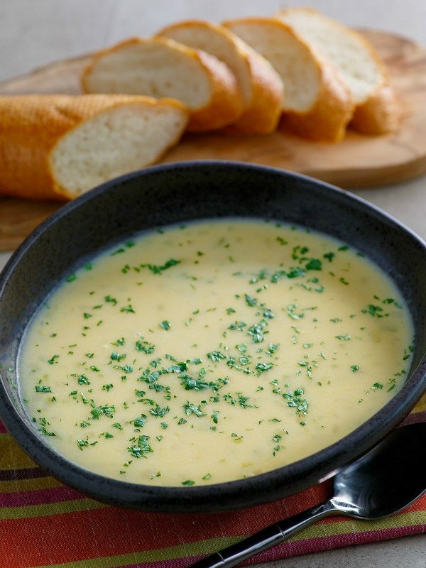 brown bowl of beer cheese soup with bread