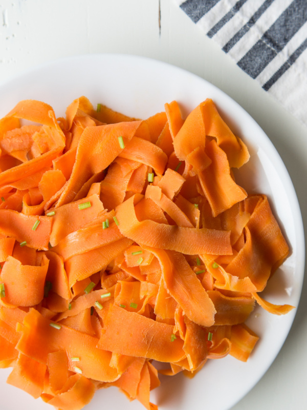 white plate of orange glazed carrot ribbons