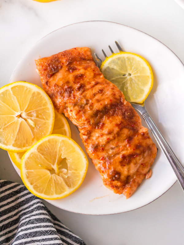 salmon fillet on plate with lemon slices