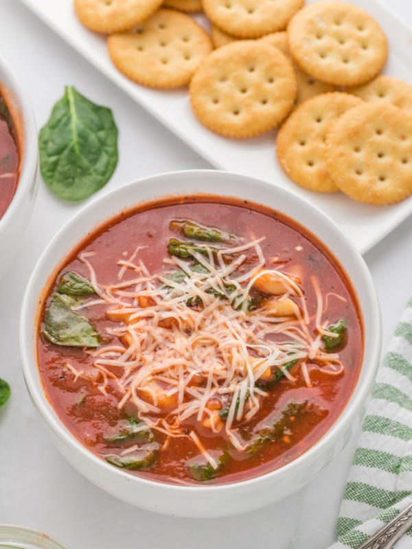 bowl of tomato florentine soup with ritz crackers on side