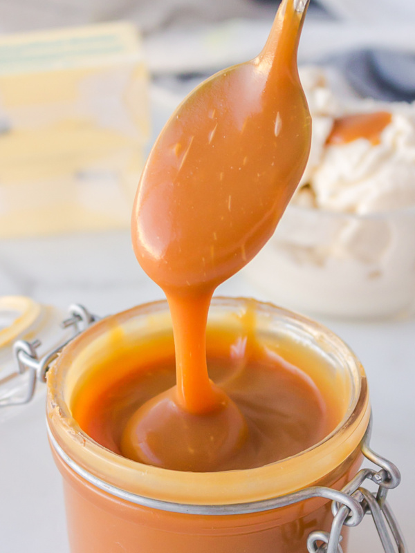 spooning caramel sauce out of jar