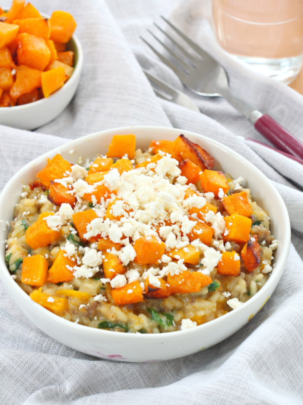 roasted pumpkin and sausage risotto in a white bowl