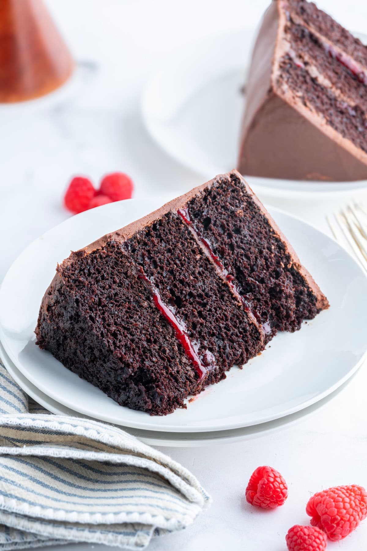 slice of double chocolate cake with raspberry filling on a plate