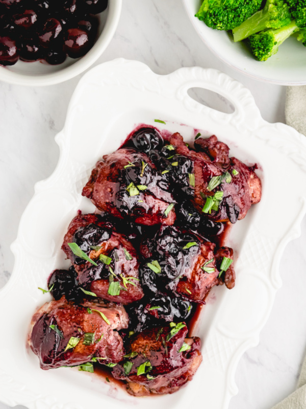 sauteed chicken with cherries in a white dish