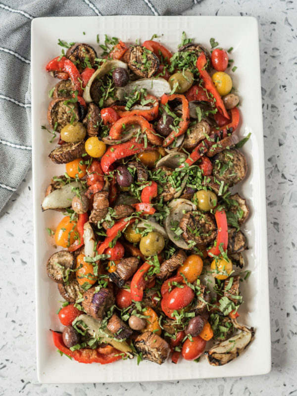 overhead shot of grilled vegetable salad on a rectangular white platter