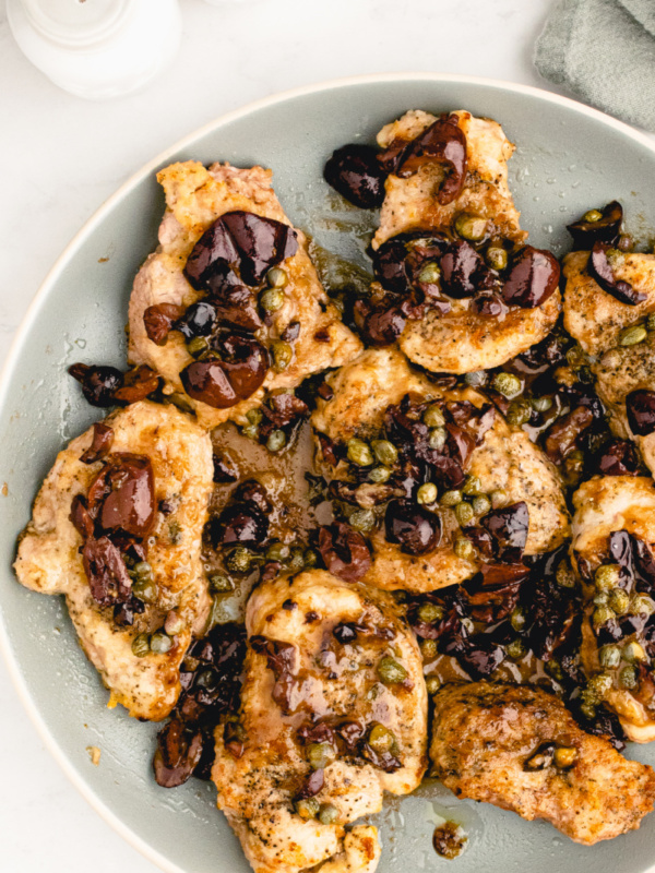 plate of pork with olives and capers