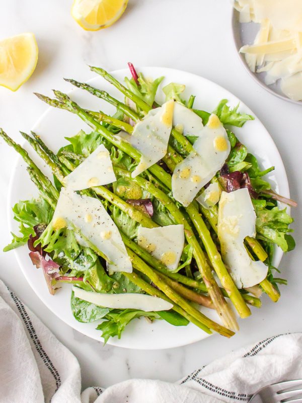 spring lettuce salad on a plate with asparagus and parmesan