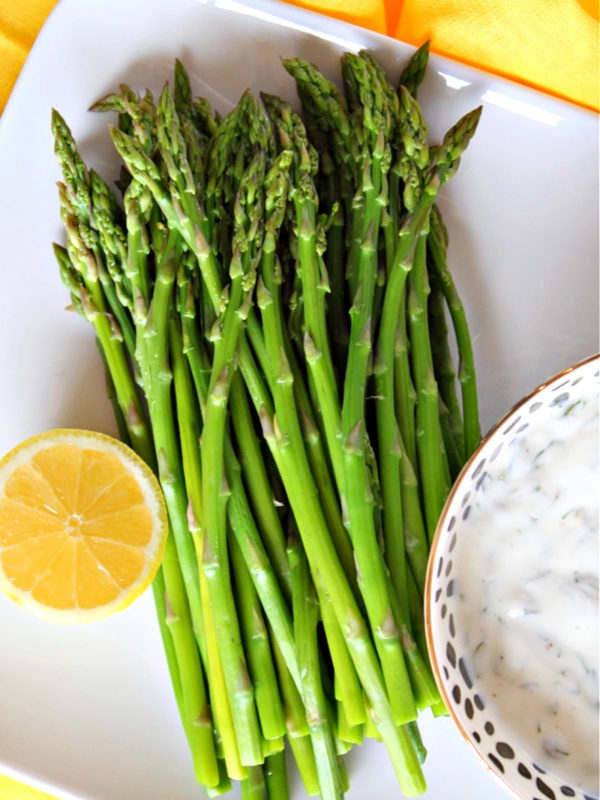 asparagus with caper dill sauce on a platter