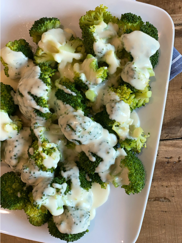 broccoli on a plate with cheese sauce