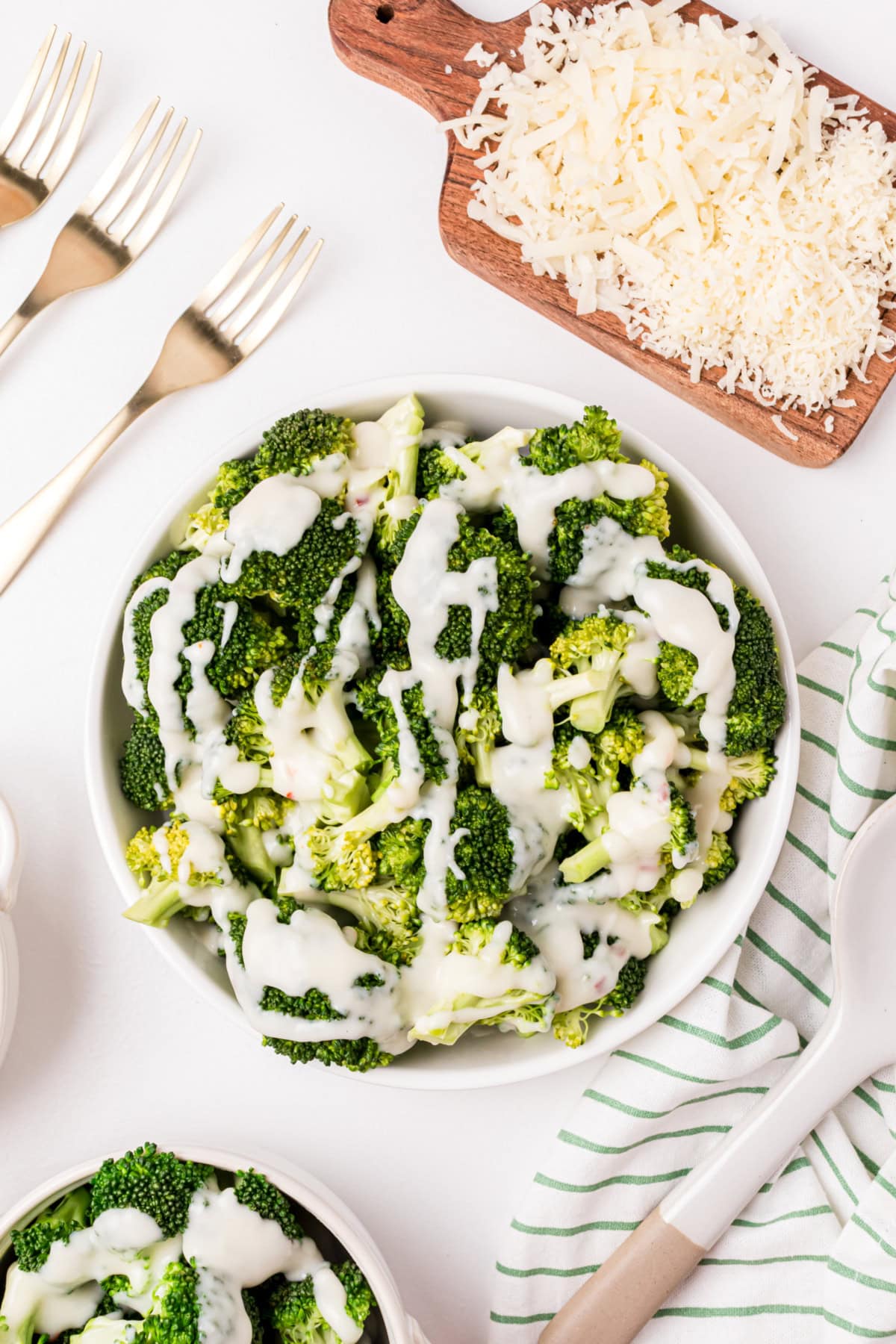 overhead shot of bowl of broccoli with two cheese sauce drizzled on top