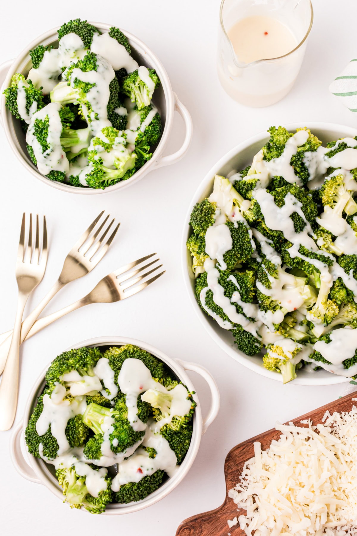 several bowls of broccoli with two cheese sauce drizzled on top