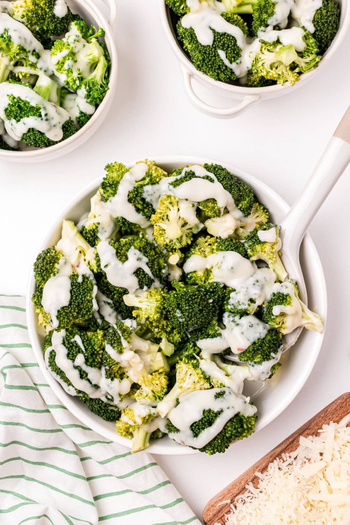 spoon in bowl of broccoli with two cheese sauce