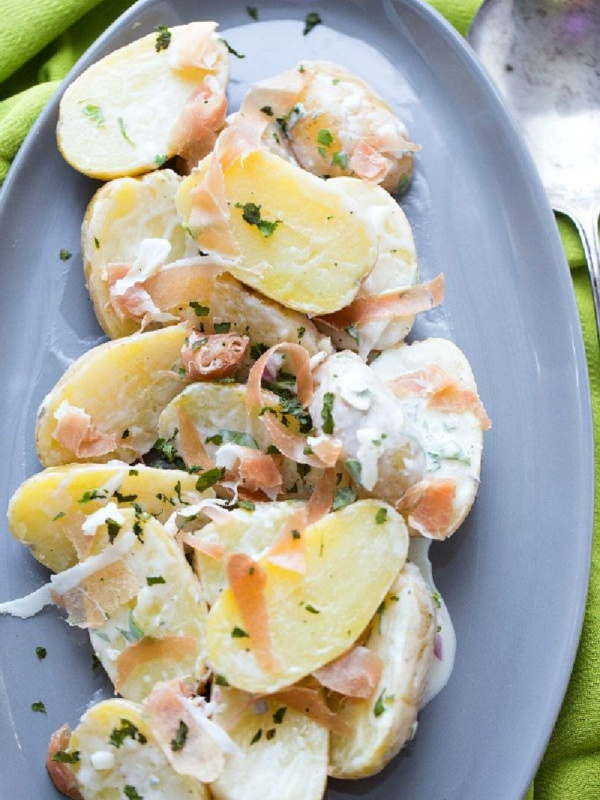 fingerling potato and prosciutto salad on a blue plate