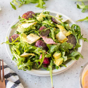 plate of grape avocado and arugula salad