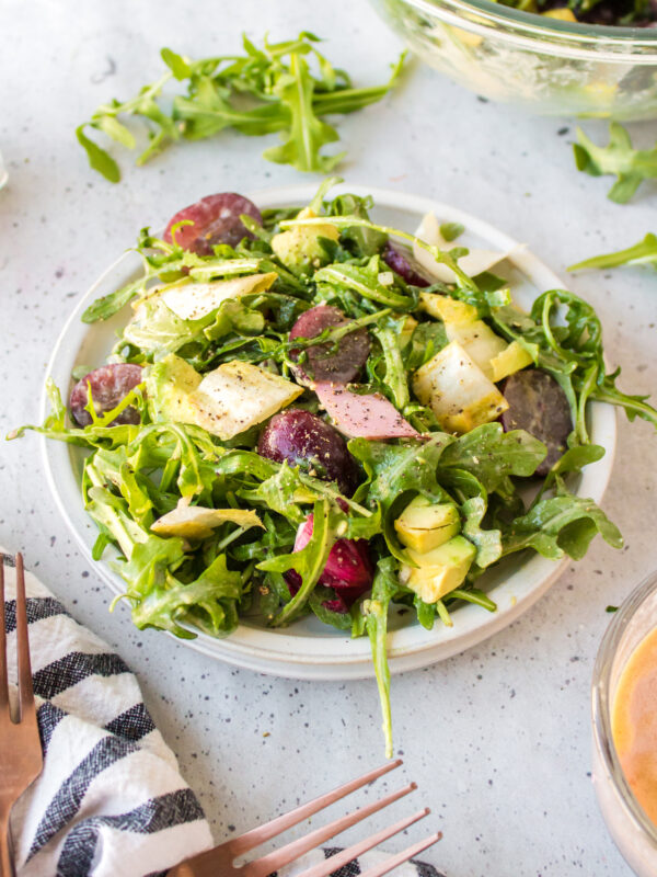 plate of grape avocado and arugula salad