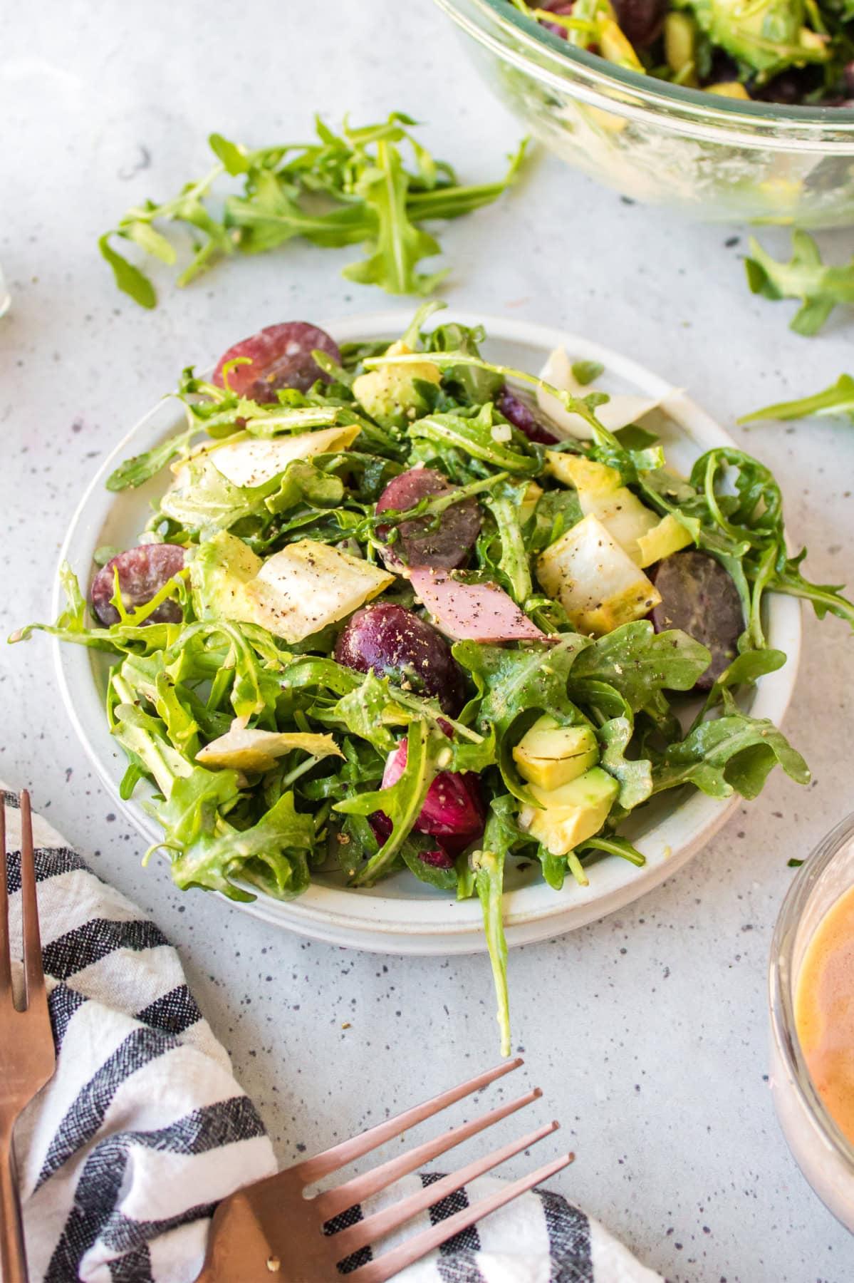 plate of grape avocado and arugula salad