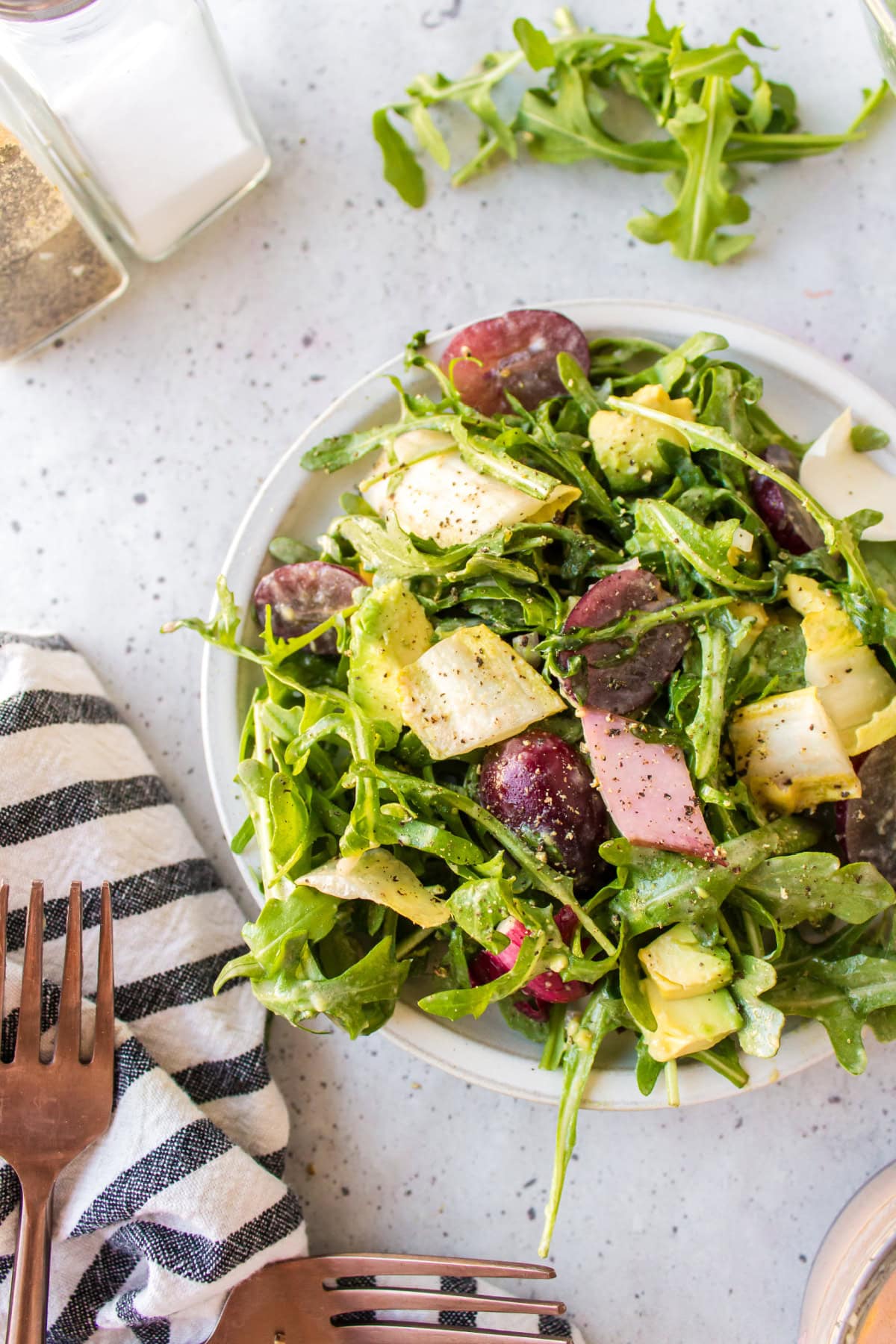 plate of grape avocado and arugula salad