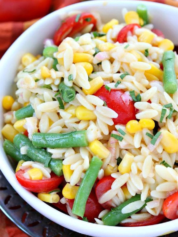 white bowl of orzo salad with corn green beans and tomatoes