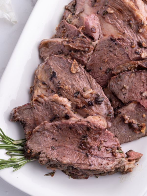 sliced leg of lamb roast on platter