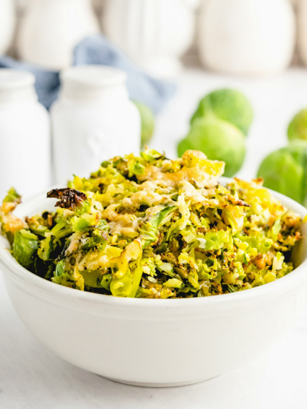 shredded parmesan brussels sprouts in white bowl