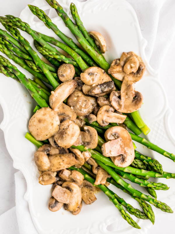 asparagus on a platter with mushroom sauce