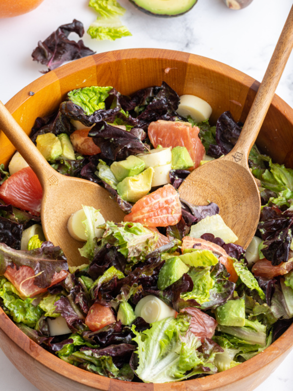 wooden bowl with servers in hearts of palm avocado salad