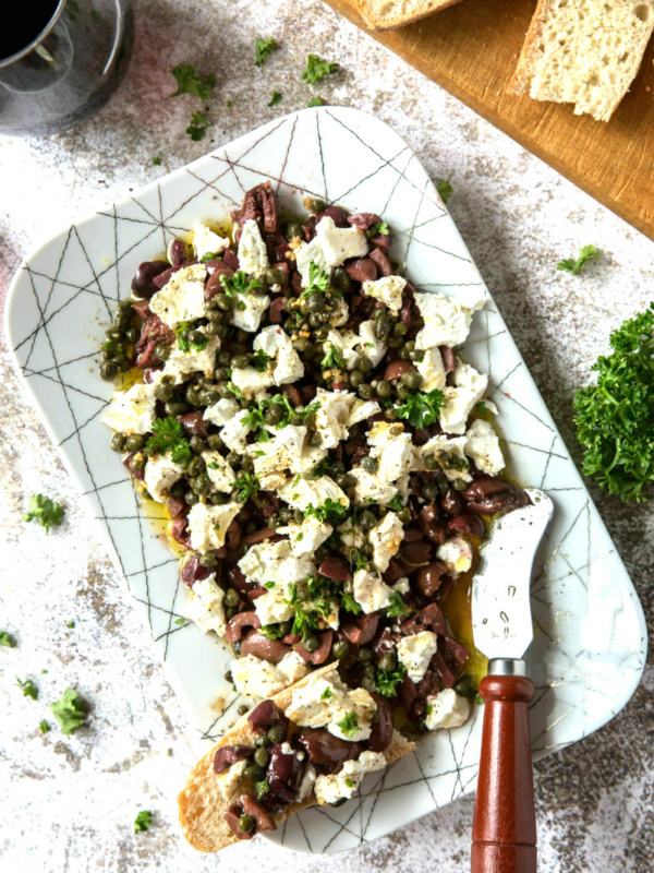 olive and goat cheese spread on a white platter