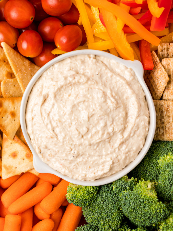 bowl of sweet caramelized onion spread surrounded by veggies and crackers