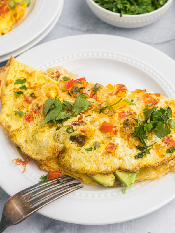 avocado manchego cheese omelette on plate with fork