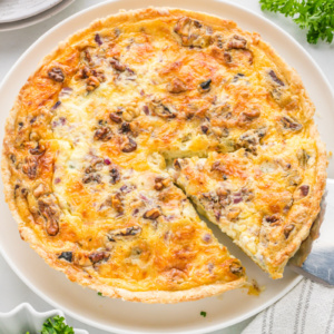 spatula taking out a slice of blue cheese and walnut quiche