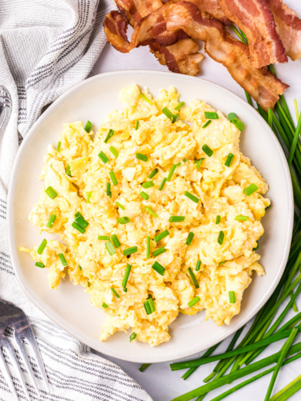 scrambled eggs on a plate with chives on top