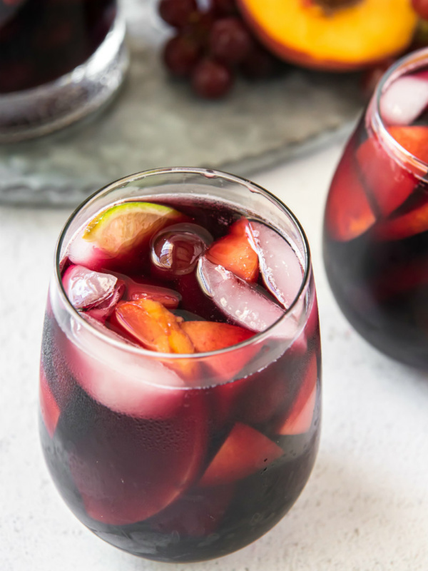 looking overhead into a glass of red wine sangria with peaches