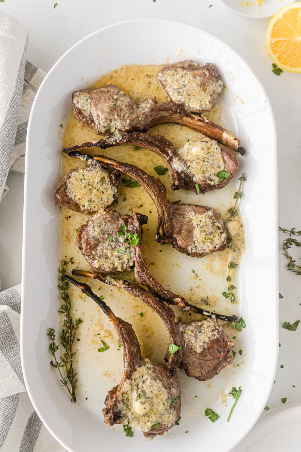 broiled lamb chops on a platter topped with lemon butter sauce