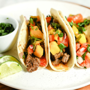 beef fajitas in flour tortillas on a serving plate