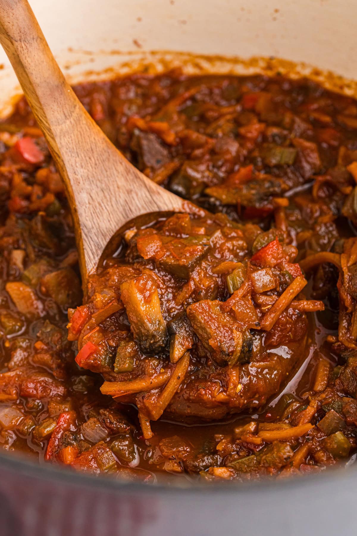 spoon in pot of bolognese sauce