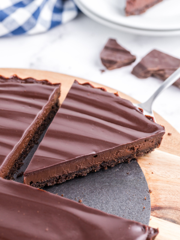 chocolate tart with slice being taken out of it