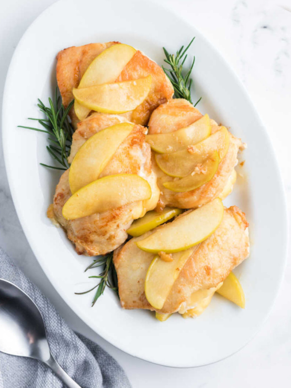 gouda stuffed chicken with apples on a white platter