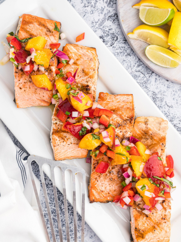 grilled salmon fillets on a platter topped with nectarine salsa