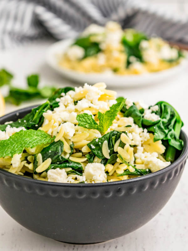 spinach with orzo and feta in a bowl