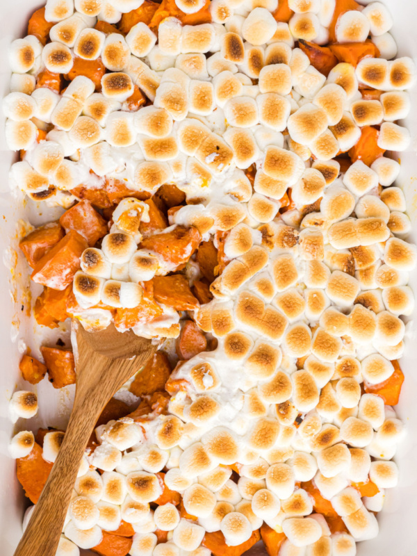 spooning out caramelized yams with marshmallows