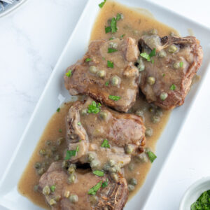 lamb chops in caper sauce on platter