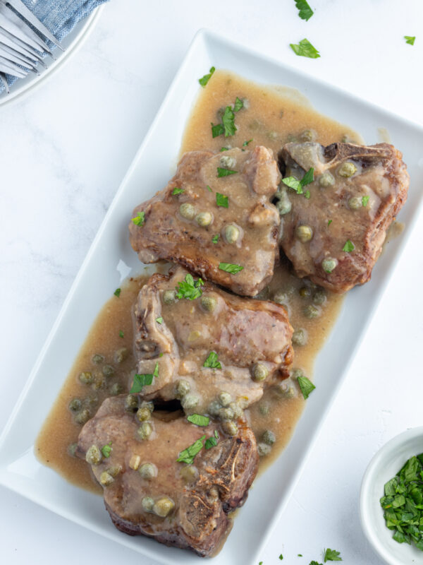 lamb chops in caper sauce on platter